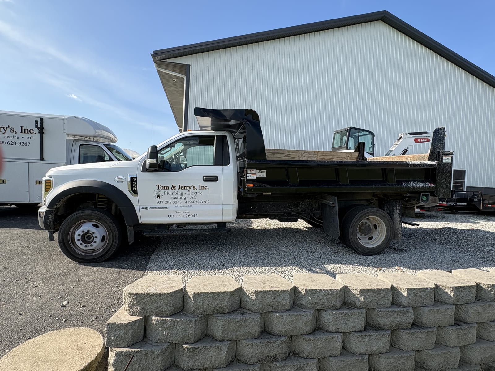 Tom & Jerry's dump truck loaded with a skid steer at the Fort Loramie shop