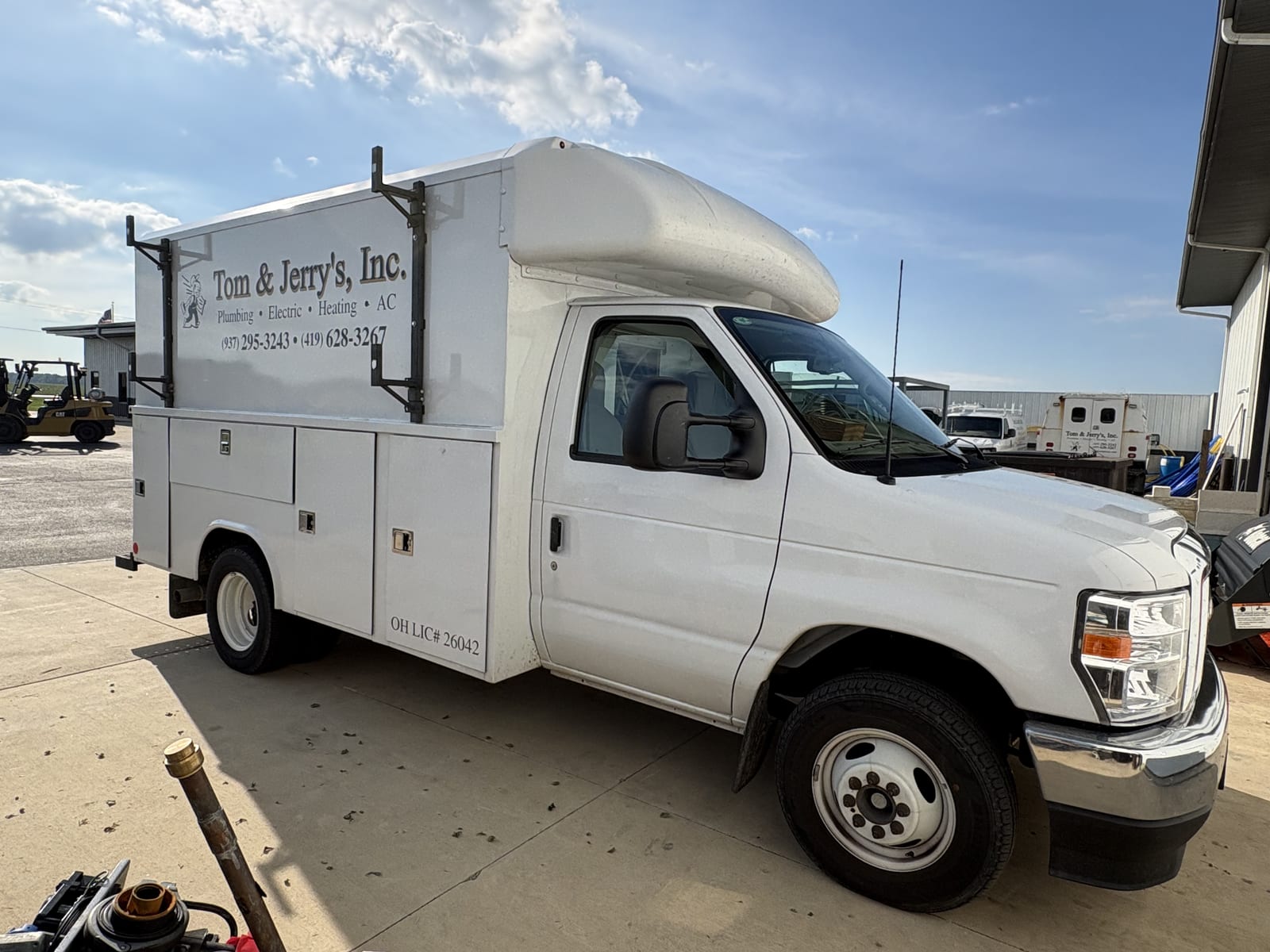 A Tom & Jerry's service truck at the Fort Loramie shop, lettered with the company name and both phone numbers